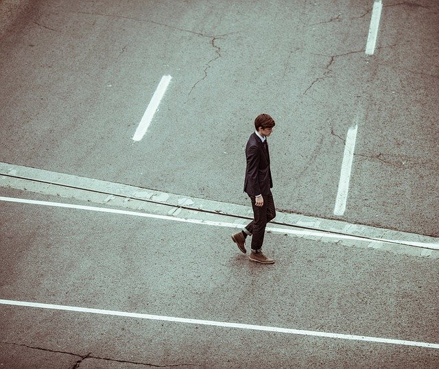 Muž v obleku kráča po ulici 